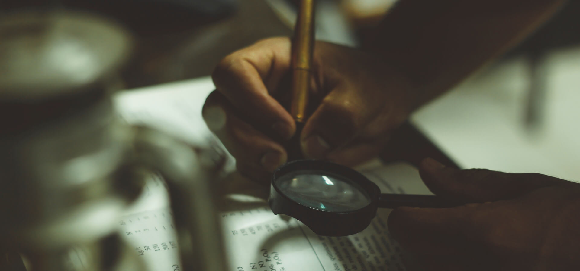 A hand holding a magnifying glass over a printed page