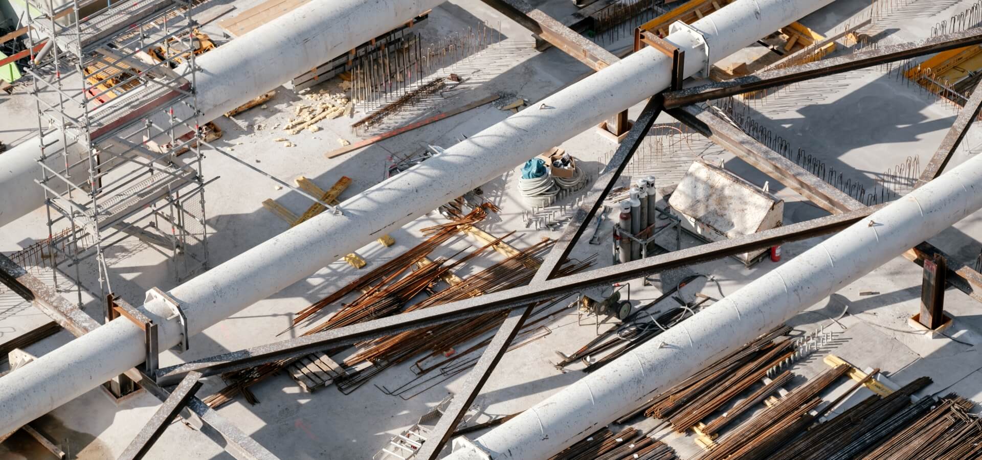 An aerial view of a construction site with pipes, steel beams and scaffolding